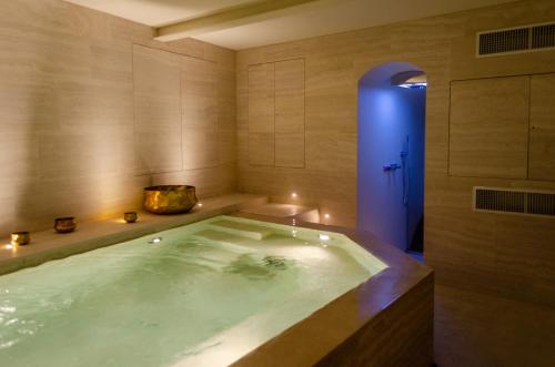 a jacuzzi tub in a bathroom with a blue door at PALAZZO ESSENZA in San Miniato