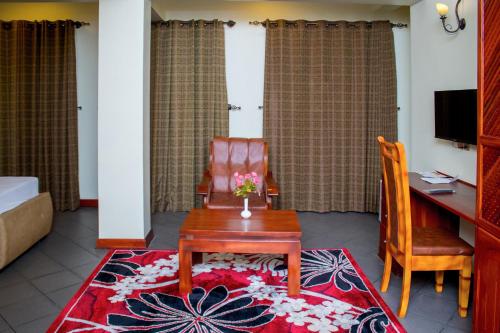 a room with a desk and a chair and a table at seven skies hotel in Arusha