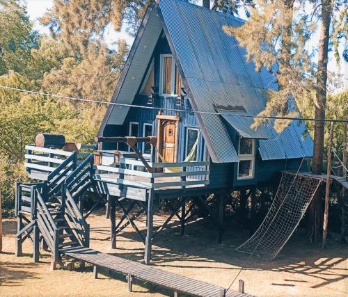 a blue house with a hammock in front of it at COEMBOTA Cabañas in Tigre