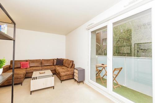 a living room with a couch and a table at Bright 68 m2 apartment near the Stade de France in Aubervilliers