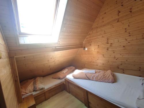 a small room with two beds in a wooden cabin at Wellness Penzion Eva in Dolní Moravice
