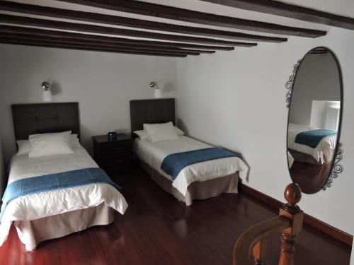 a bedroom with two beds and a mirror at Precioso Apartamento en el Centro in Seville