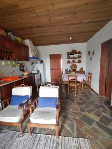 a kitchen and living room with a table and chairs at Casa da Tia Luísa in Montoito