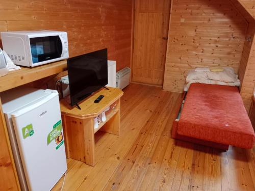 a small room with a microwave and a desk with a tv at Wellness Penzion Eva in Dolní Moravice