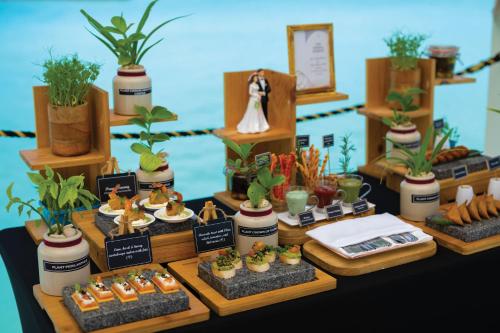 a table with potted plants and food on display at VARU by Atmosphere - Premium All Inclusive with Free Transfers in North Male Atoll
