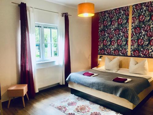 a bedroom with a bed and a large window at Waldschenke Stendenitz Übernachten im Wald am See in Neuruppin