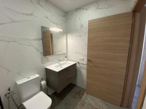 La salle de bains est pourvue de toilettes, d'un lavabo et d'un miroir. dans l'établissement Casa Feria, à Algodonales