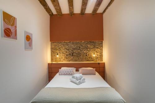 un lit dans une chambre avec un mur en pierre dans l'établissement La Baronne- Chaleureux T2, à Nantes