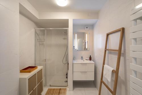 a white bathroom with a shower and a sink at Le Bienveillant - T3 proche Jardin des Plantes in Nantes