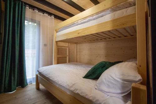 a bedroom with a bunk bed with a green curtain at Złota Szyszka Radawa in Radawa
