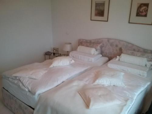 2 Betten in einem Zimmer mit weißer Bettwäsche und Kissen in der Unterkunft Urlaubs Oase in Telgte