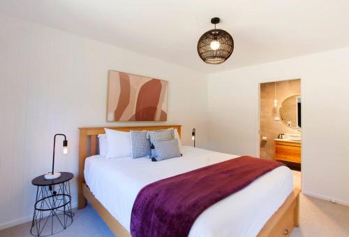 a bedroom with a large bed with a purple blanket at Bush and Beach Family Retreat in Adventure Bay