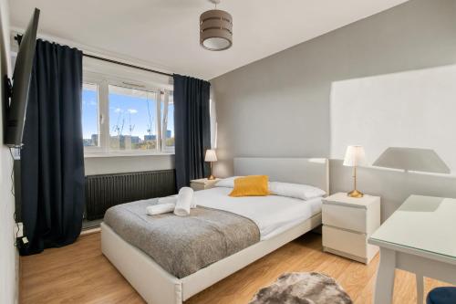 a bedroom with a white bed and a window at Kings Cross apartment 4 BR in London
