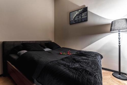 1 dormitorio con 1 cama con manta negra en Krakowskie30 Loft2 na deptaku, en Lublin