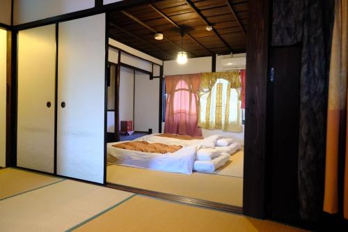a bedroom with a bed in a room with a mirror at Sanjyomisasagi Umenotoan in Kyoto