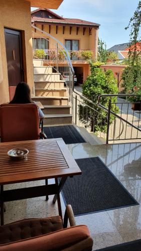 a woman sitting in a chair next to a table at Pensiunea Select in Arad