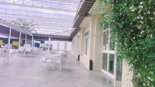 un patio con mesas y sillas blancas en un edificio en Pensión los Ángeles, en La Puebla de Cazalla