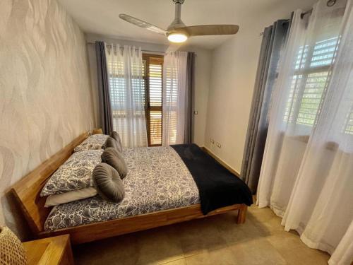 um quarto com uma cama com almofadas e janelas em Remarkable 1-Bed Apartment & Sea Views - Sleeps 2 em Finestrat