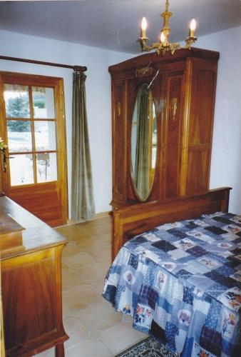 une chambre avec un lit, une commode et un miroir dans l'établissement Mas du Garidel l Appartements avec piscine privée proche Ardèche à Saint Julien de Peyrolas, à Saint-Julien-de-Peyrolas