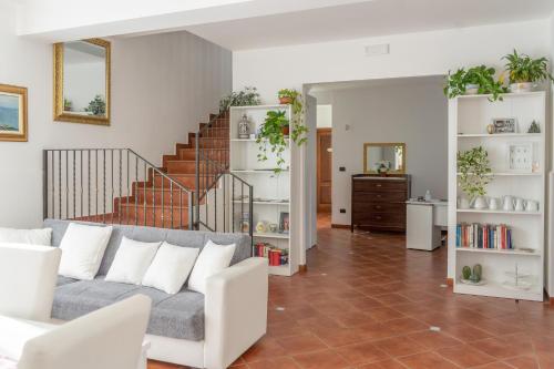 a living room with a couch and a staircase at B&B BOUTIQUE DI CHARME "ETNA-RELAX-NATURA" in Zafferana Etnea
