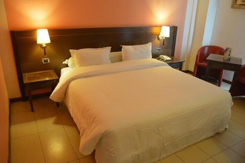 Een bed of bedden in een kamer bij Djeuga Palace Hotel