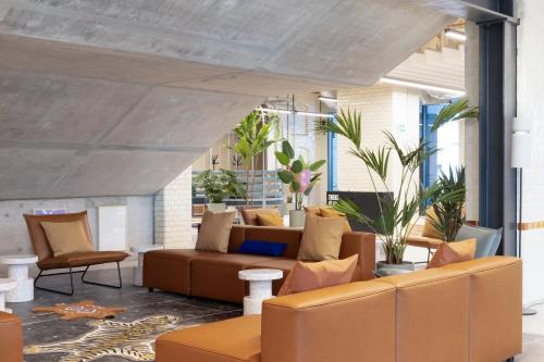 an outdoor living room with a couch and chairs at Basecamp by Xior Wrocław in Wrocław