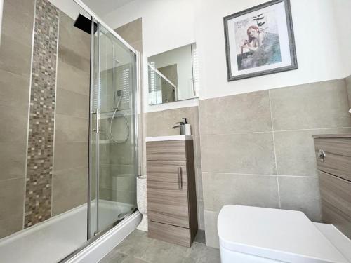 uma casa de banho com uma cabina de duche em vidro e um WC. em Unique & Luxurious 2 Bedroom City Centre Apartment em Nottingham