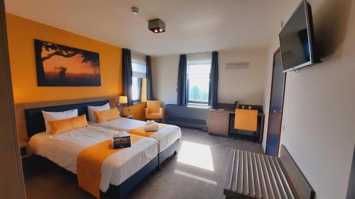 a bedroom with a bed and a flat screen tv at Azur en Ardenne in Durbuy