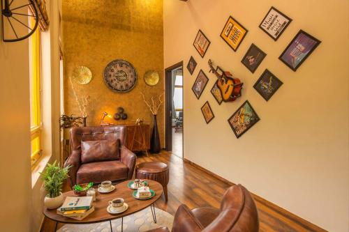 a living room with a table and leather chairs at StayVista at Spirits Unplugged with Outdoor Pool - Karyali in Nāldera