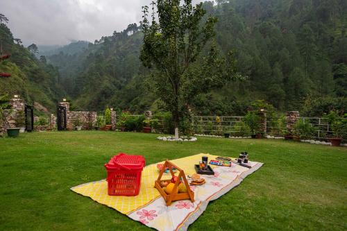 a picnic table in a field with a view of a mountain at StayVista at Spirits Unplugged with Outdoor Pool - Karyali in Nāldera