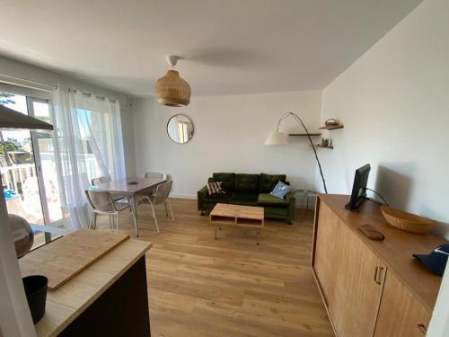 sala de estar con sofá y mesa en Les Pins Penchés, en Villers-sur-Mer