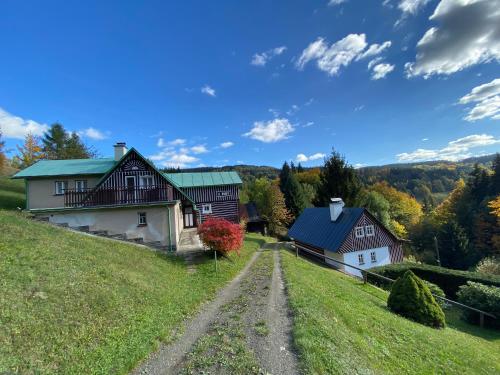 two houses on a hill with a dirt road at Apartmán HYGGE Bratrouchov in Jablonec nad Jizerou