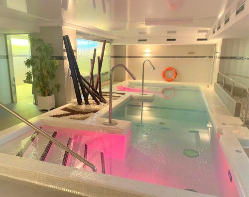 ラレードにあるHotel Playamar Spaのピンクの水を使用した客室内のホットタブ