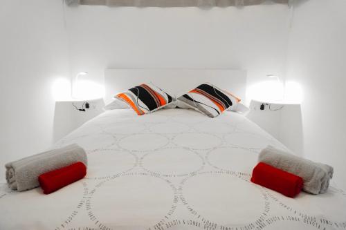 un letto bianco con due cuscini rossi sopra di Ocean view, Playa San Juan. a Guía de Isora
