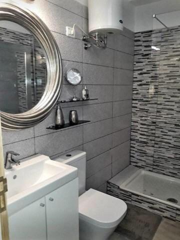 a bathroom with a sink and a toilet and a mirror at CasaBarco in Costa Del Silencio