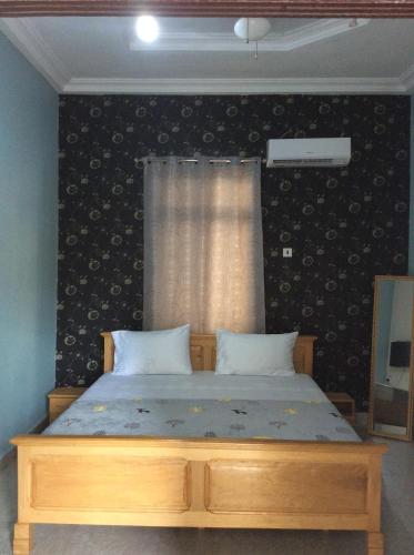 庫馬西的住宿－Patayo Lodge，一间卧室配有一张木框床和窗户。