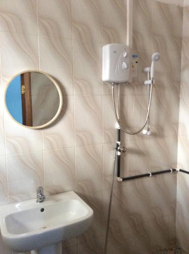 a bathroom with a sink and a mirror at Patayo Lodge in Kumasi