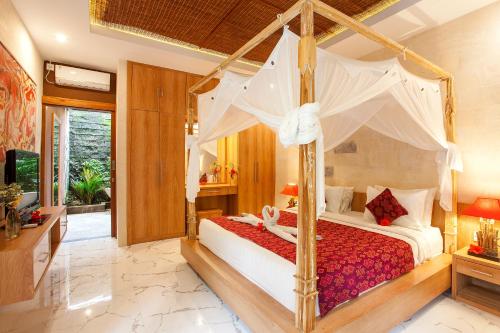 een slaapkamer met een hemelbed en een televisie bij Nidhi Private Villas in Ubud