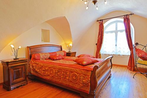 Un dormitorio con una cama con almohadas rojas. en Les Fleurs de Marie, en La Cresse