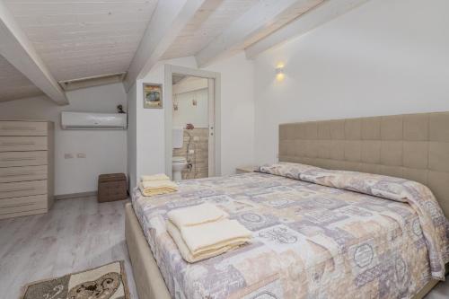 Villetta a Mare في أولبيا: غرفة نوم بسرير كبير عليها مناشف