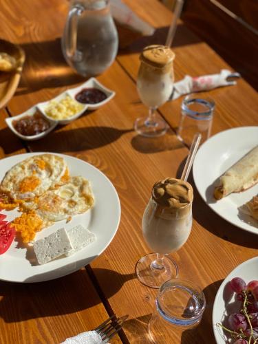 a table with plates of food and glasses of drinks at JOEN Village in Librazhd
