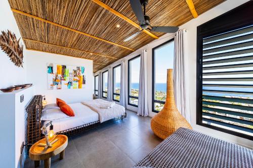 a bedroom with a bed with a view of the ocean at Villa Coco Palm ***** in Saint-Pierre