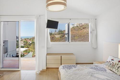 a white bedroom with a bed and a window at Casa el Quijote in San Bartolomé de Tirajana