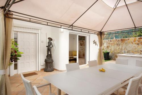 a kitchen and dining room with a white table and chairs at Casa el Quijote in San Bartolomé de Tirajana