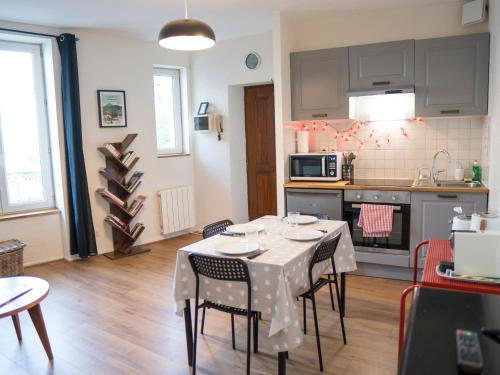 - une cuisine et une salle à manger avec une table et des chaises dans l'établissement La Grande Maison Clermont - Appartements centre ville, à Clermont-Ferrand
