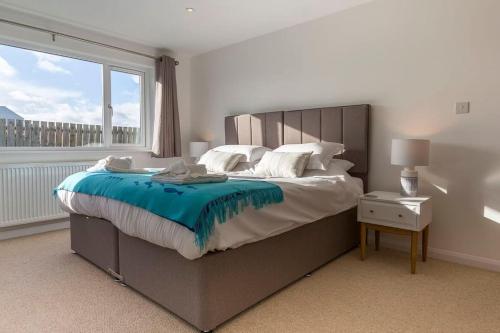 Un dormitorio con una cama grande con una ventana grande. en POLDARE - Widemouth Bay Bude Cornwall, en Bude