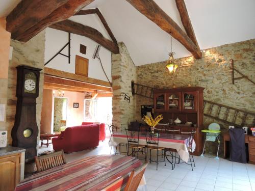un salon avec une table et des chaises dans un immeuble dans l'établissement Gîte LA FENIAL, à Montredon-Labessonnié