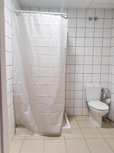 a bathroom with a toilet and a shower curtain at Albergue la Fontanina ALCC00043 in Mata de Alcántara