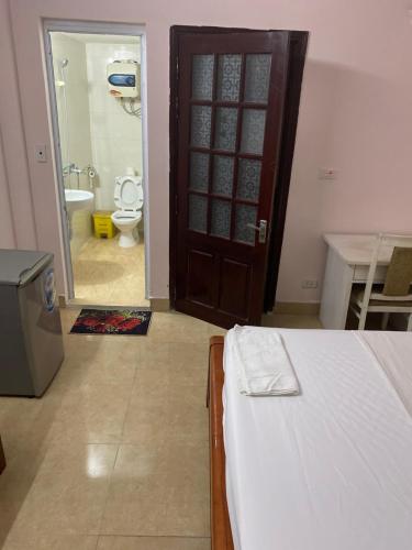 a bedroom with a bed and a bathroom with a toilet at Hoàng Kiên Hotel in Hanoi