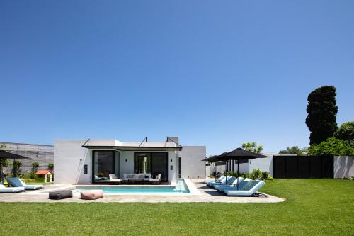 a house with a swimming pool and some chairs at Physis Villas - Metal & Wood in Pigi